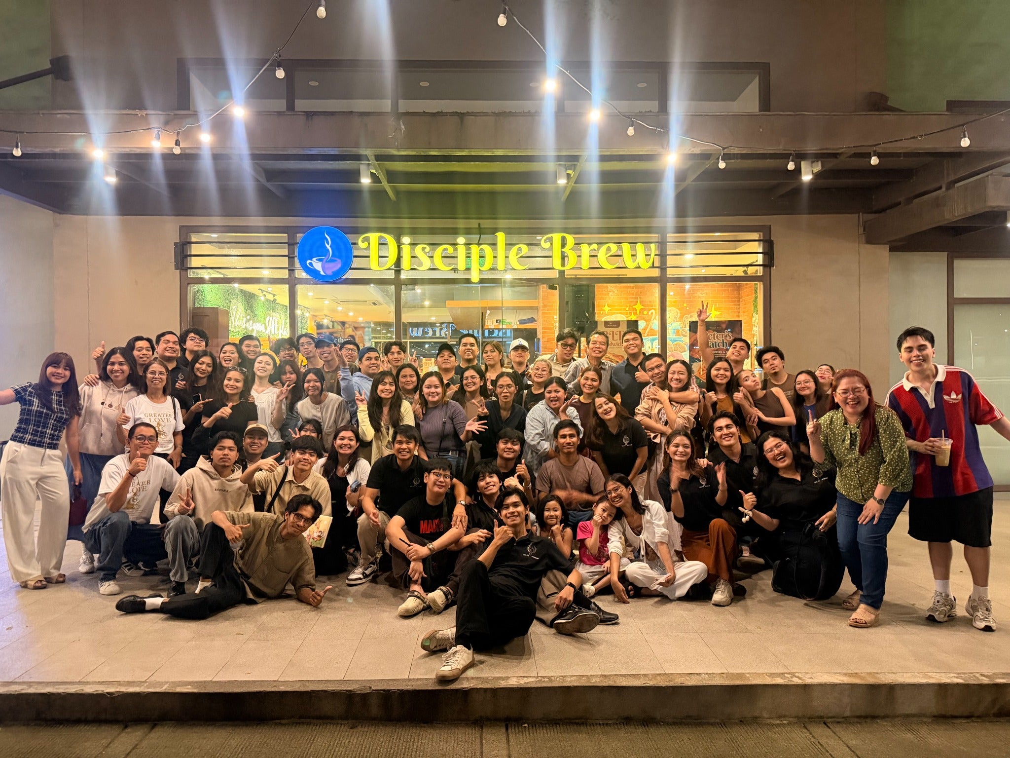 The Disciple Brew community gathered outside the café beneath the lights