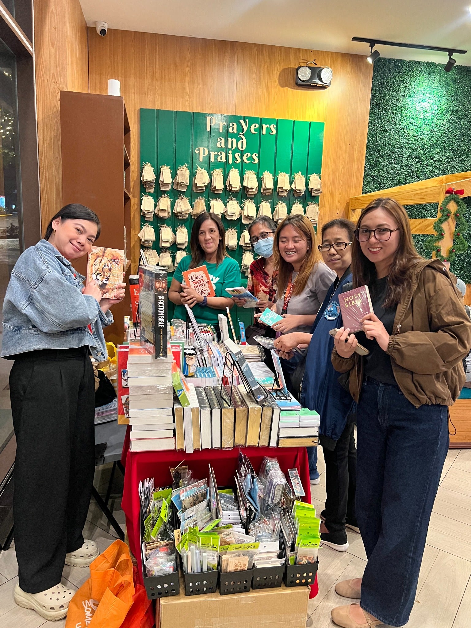 Community members smiling around a book display at Disciple Brew