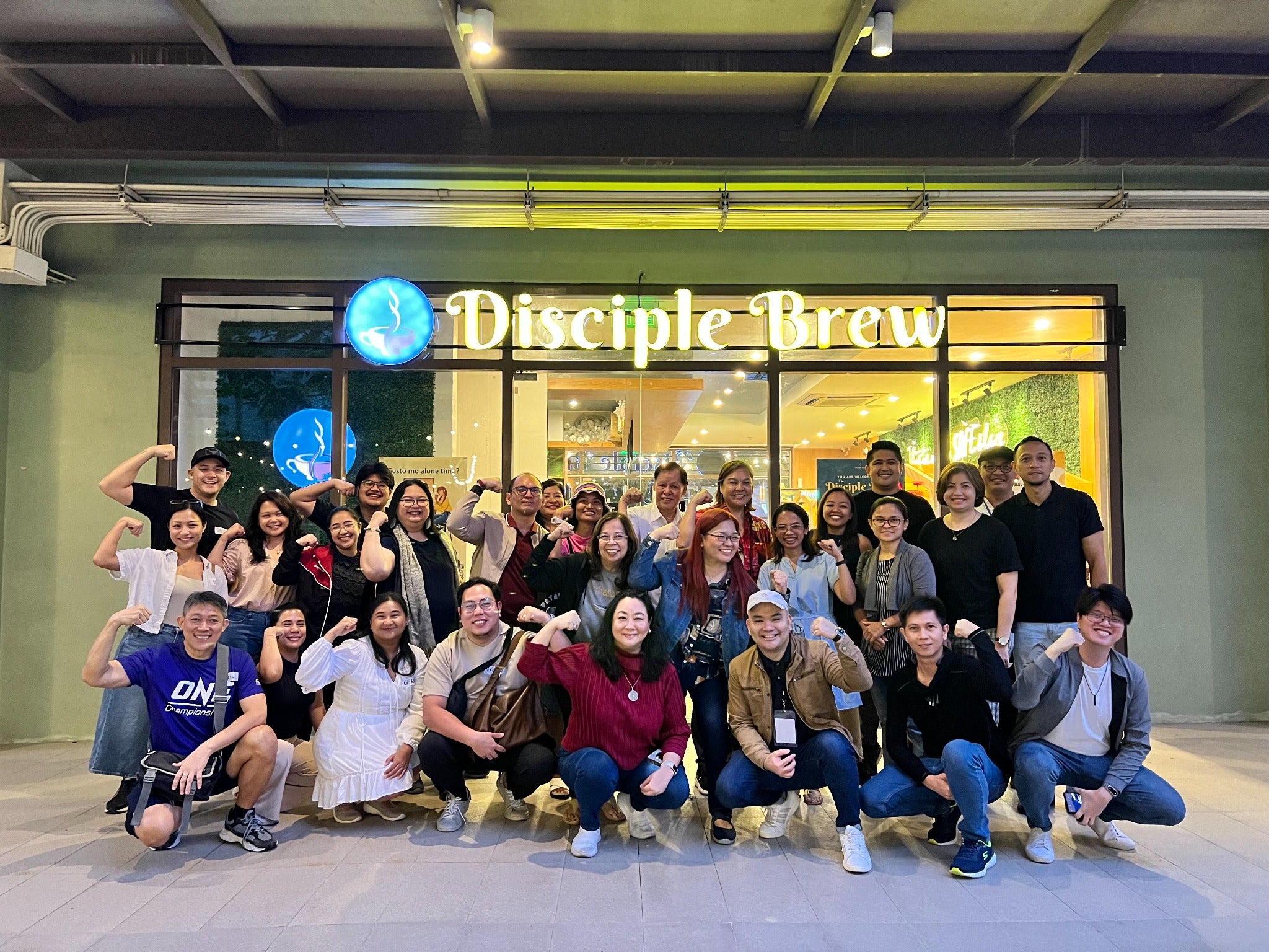 Community members posing together outside Disciple Brew