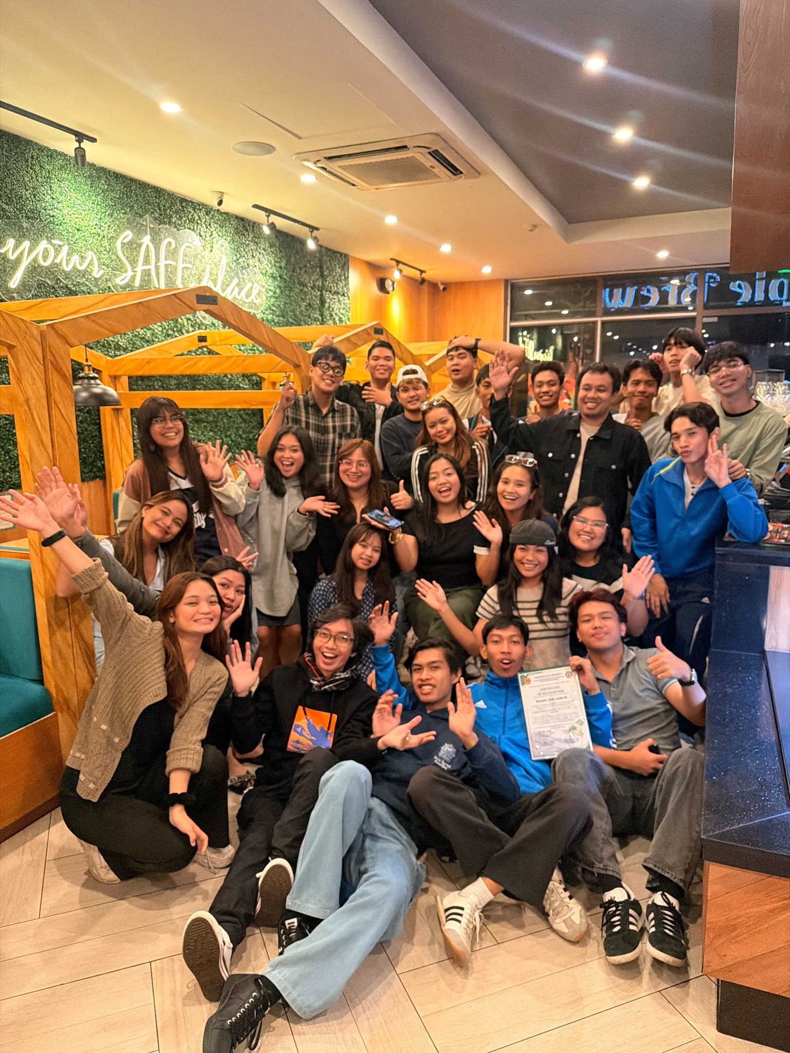 The Disciple Brew community smiling and waving together inside the café
